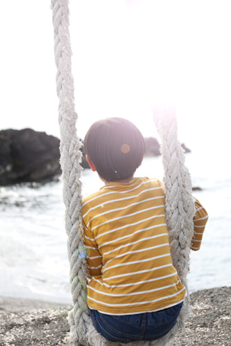 海辺の手作りブランコに乗る子供