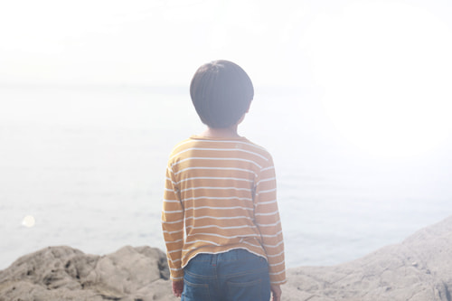 海を眺める子供の後姿
